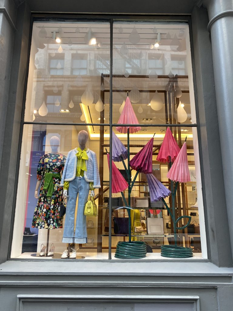 Kate Spade spring windows 2023. Visual Citi created these whimiscal custom made umbrellas that were fabricated to form flower displays with green hose details.